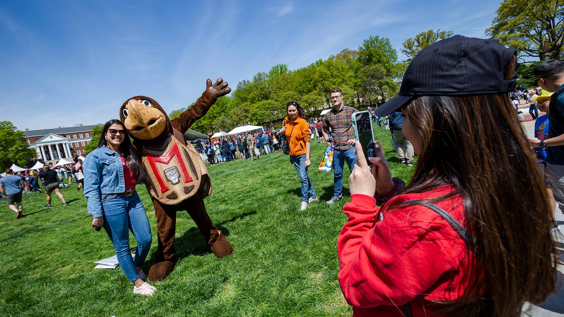 A young student hanging out with Testudo on McKeldin Mall at Maryland Day.